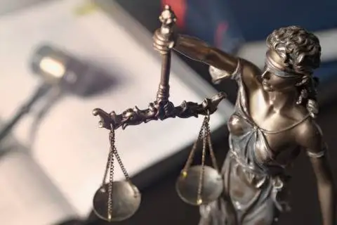 Justice statue holding scales, symbol of law and fairness.