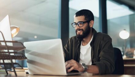 Business professional working on a laptop to overcome software scalability challenges.