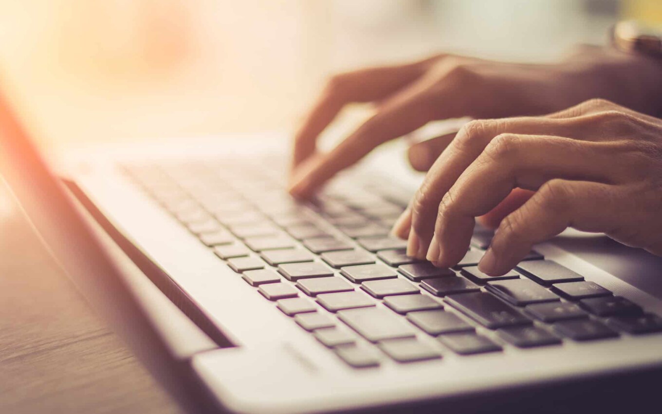 Side view of a woman using laptop, searching web, browsing information