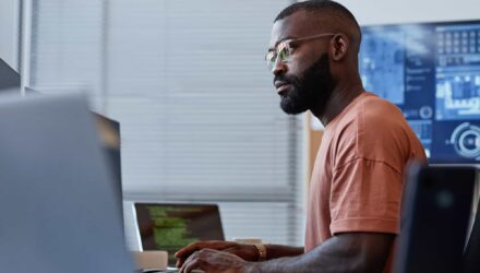 IT Systems Analysis Process | i3solutions Business professional analyzing IT systems on computer screen in modern office.