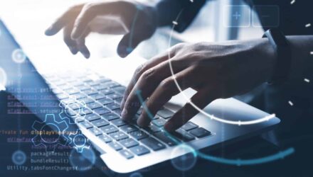 Business professional coding on laptop for web app development.