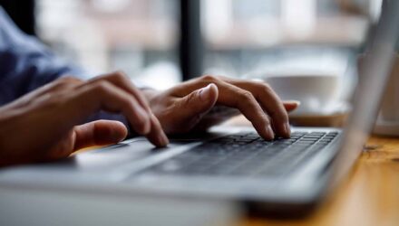 Data Migration to Scalable Database | i3solutions Person typing on a laptop keyboard, representing data migration and database solutions.