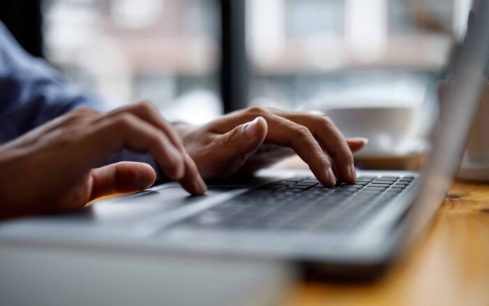 Close up of hands typing on computer keyboard panoramic banner