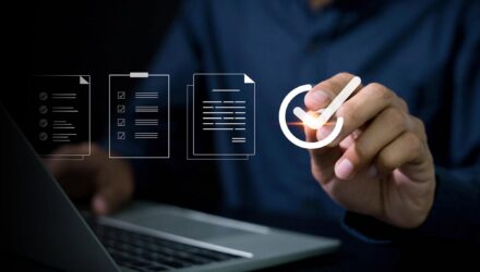 Business professional analyzing IT systems with digital icons and checklist.
