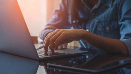 Streamlined SharePoint Content Management | i3solutions Person managing SharePoint content on laptop for organized information control.