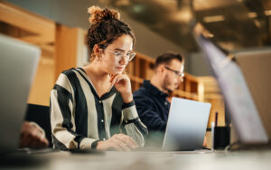 Young Woman Working on Computer in a Modern Bright Office