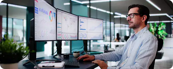 Data Analyst Monitoring Multiple Screens | i3solutions Enterprise data analyst managing structured data within Microsoft Dataverse across multiple applications.