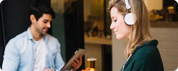 Customer Support with Headphones at i3solutions | i3solutions Customer using a secure Microsoft Power Pages self-service portal to access account information and submit support requests.