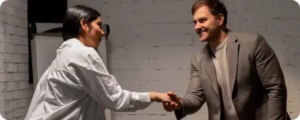 Businesspeople Shaking Hands in Office | i3solutions Business partners collaborating securely through a Microsoft Power Pages external portal.
