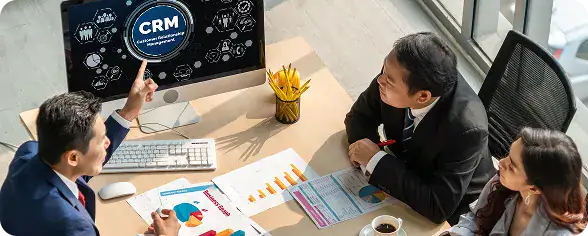 Business Meeting Discussing CRM Solutions | i3solutions Enterprise team reviewing Dynamics 365 CRM dashboards and ERP reporting analytics for unified business operations.