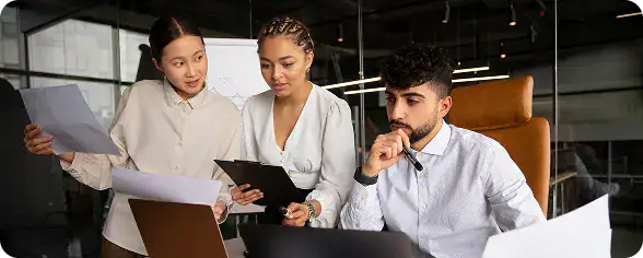 Business Meeting with Diverse Team | i3solutions Enterprise team reviewing documents to define LLM governance policies and guardrails before scaling.