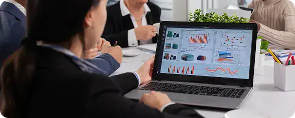 Business Meeting Analyzing Data on Laptop | i3solutions Enterprise leader reviewing real-time operational dashboards enabled by integrated data across business systems.