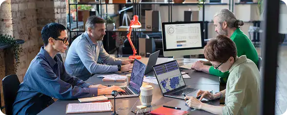Team Collaborating on Laptops in Office | i3solutions Enterprise team planning SharePoint migration and modernization strategy.