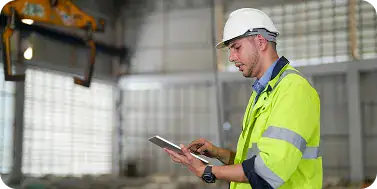 Construction Worker Using Digital Tablet | i3solutions Field team member accessing a progressive web application in a remote work environment