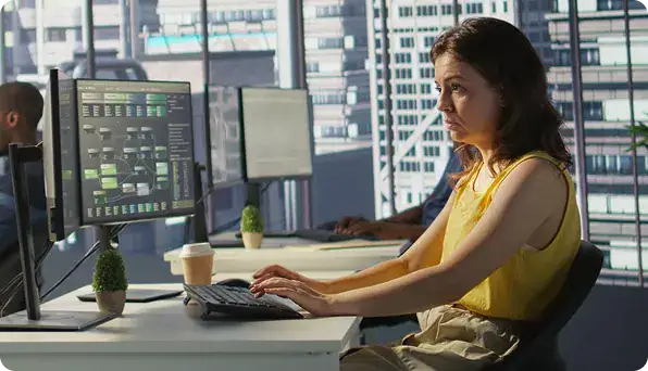 Businesswoman Working on Computer in Office | i3solutions A Dynamics 365 specialist manages enterprise CRM and ERP delivery across a governed Microsoft platform environment.
