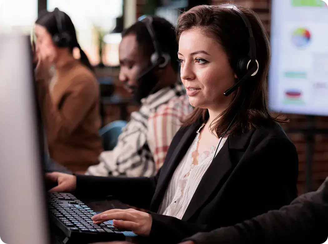 IT Support Team at Work | i3solutions Customer support team with headsets working at computers in an office.