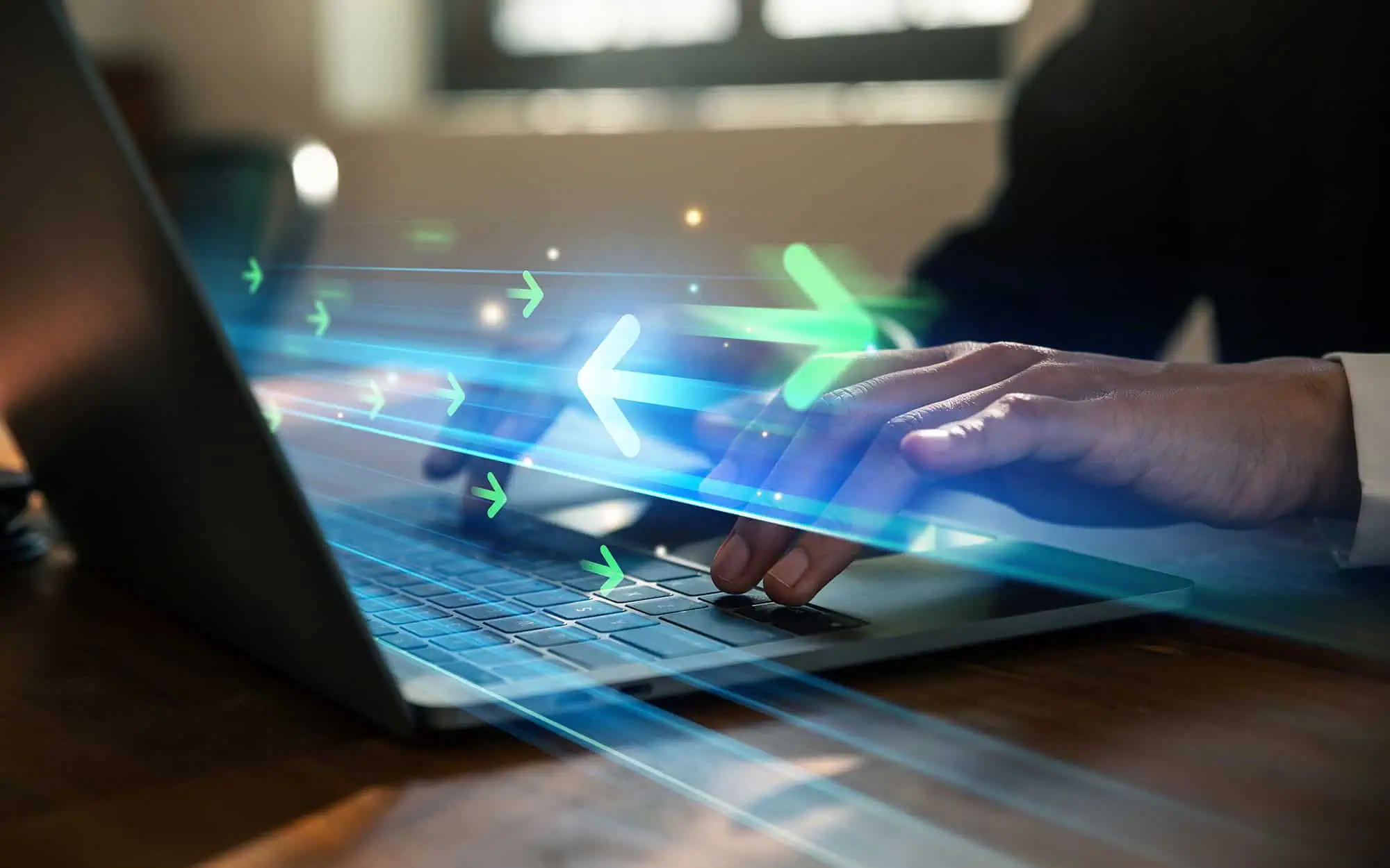 Innovative Data Transfer Technology | i3solutions Person using a laptop with digital data transfer graphics overlay.