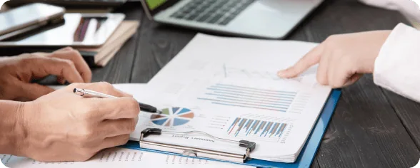 Business Meeting Analyzing Data Charts | i3solutions Business professionals reviewing data charts and graphs during a meeting.