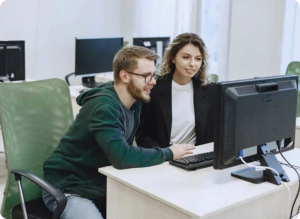 IT Team Collaborating on Software Development | i3solutions Two professionals working together at a computer in an office setting.