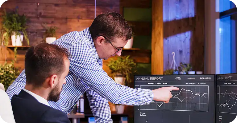Two professionals analyzing data on computer screens in a modern office.
