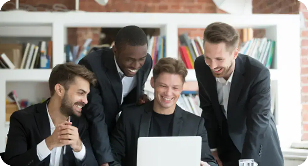 Group of diverse professionals collaborating around a laptop in an office.