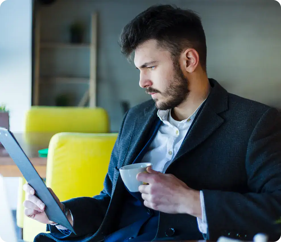 Businessman Using Digital Tablet for Work | i3solutions Businessman in formal attire using tablet in modern office setting.