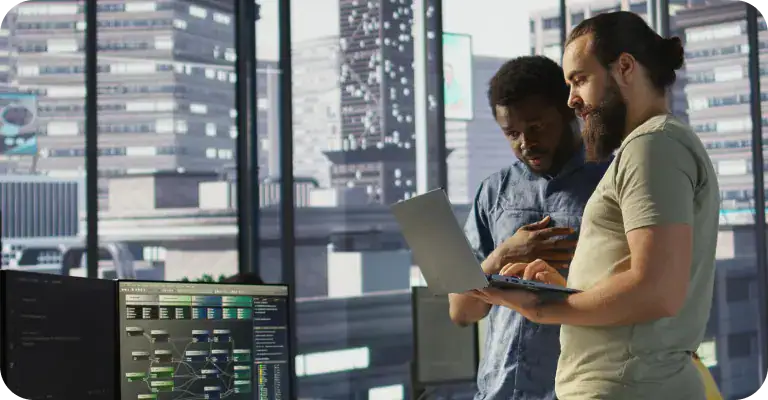 Business Professionals Discussing Data Analysis | i3solutions Two business professionals analyzing data on a tablet in a modern office.