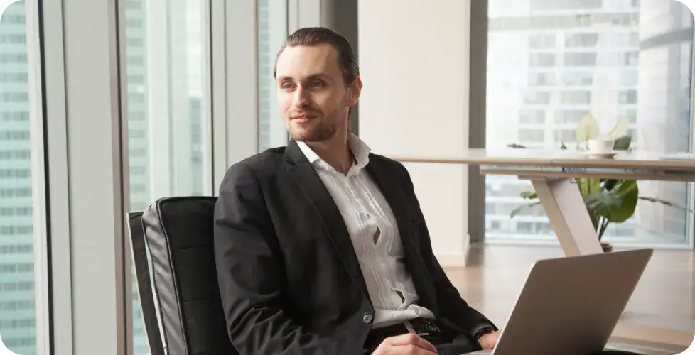 Businessman Using Laptop in Office | i3solutions Business professional working on a laptop in a modern office setting.