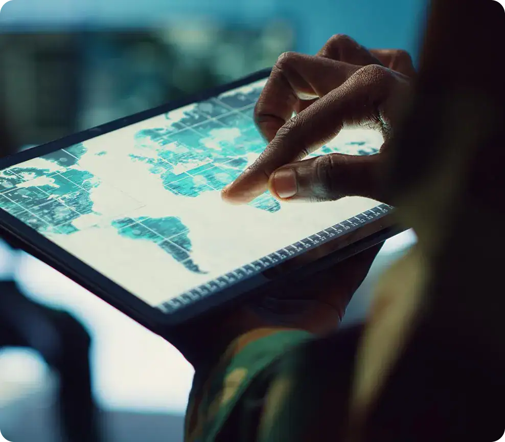 GIS Data Analysis on Tablet | i3solutions Person analyzing geographic data on a tablet with maps and charts.
