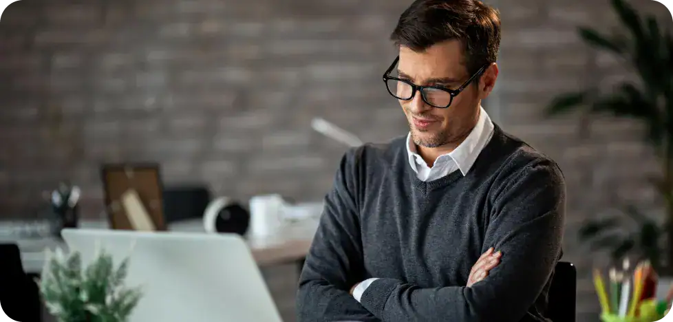 Business professional using a laptop in a modern office setting.