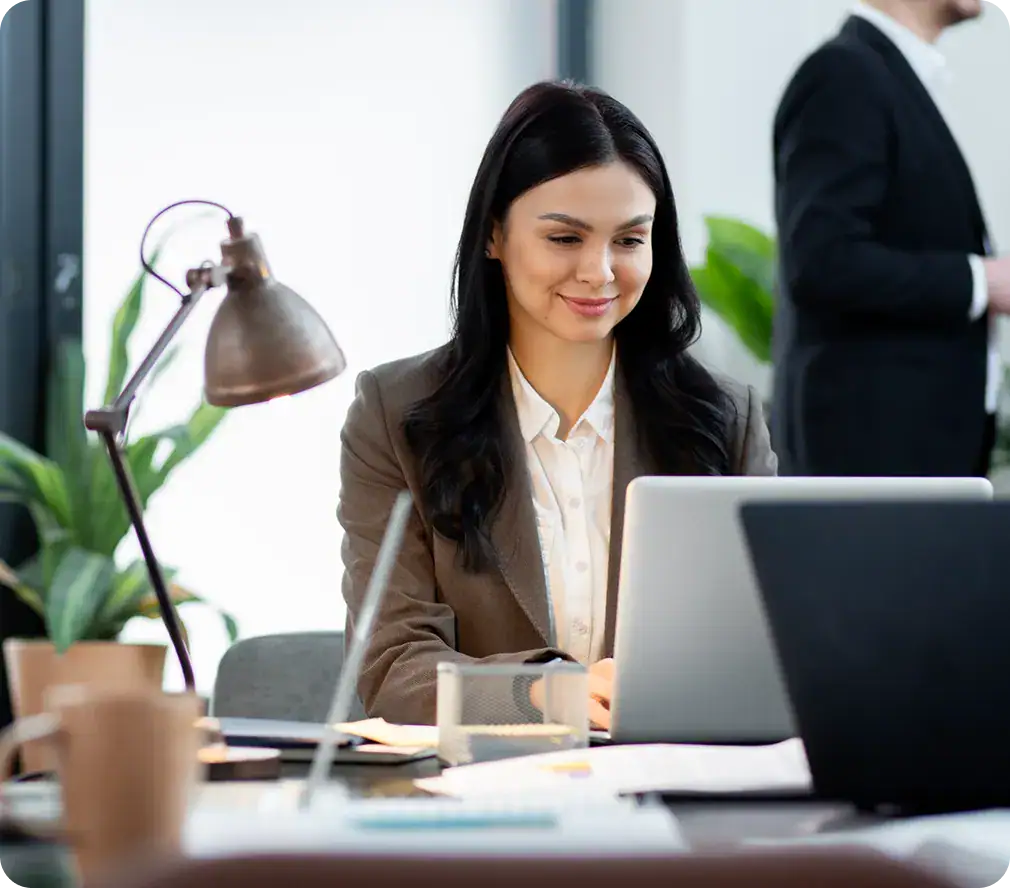 Businesswoman working on laptop in modern office environment.