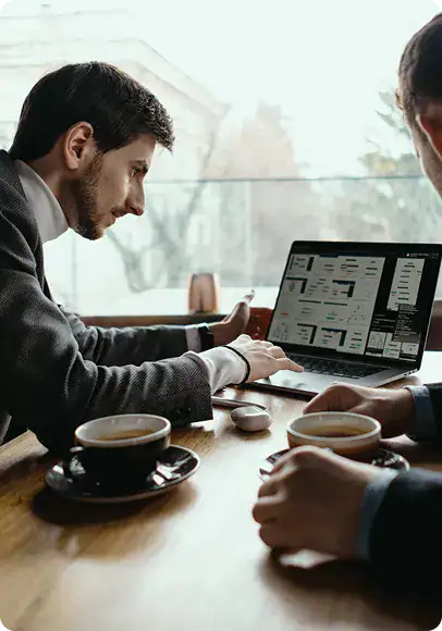 i3solutions Business Meeting Business professionals discussing data on laptops in a modern office.