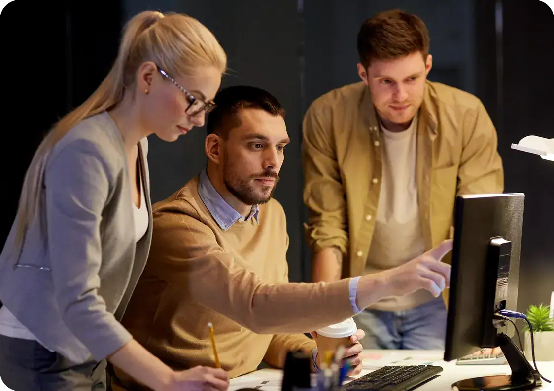 Team working together on a computer for project recovery services.