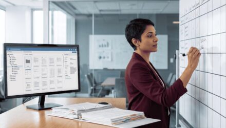 Professional woman analyzing data on whiteboard in modern office.