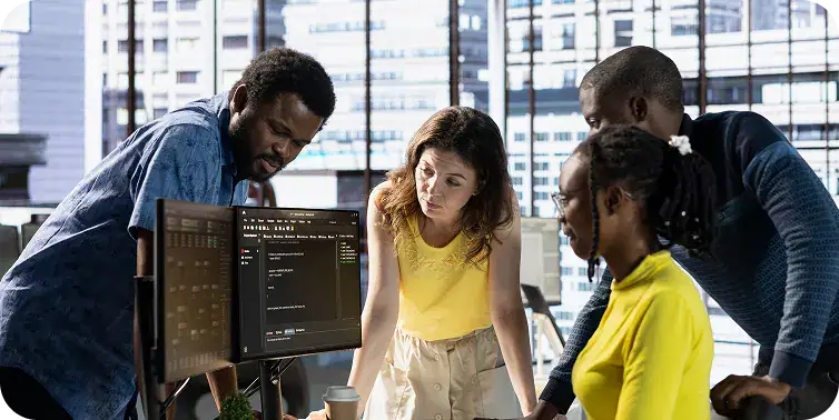 Diverse team working together on coding project in modern office.