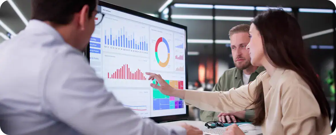 Business Meeting Analyzing Data on Screen | i3solutions Team discussing data analytics and Power Platform integration in a modern office.