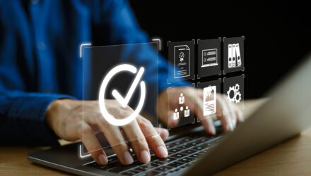 Person Using Futuristic Digital Interface with Checkmark | i3solutions Person using futuristic digital interface with checkmark and icons on laptop.