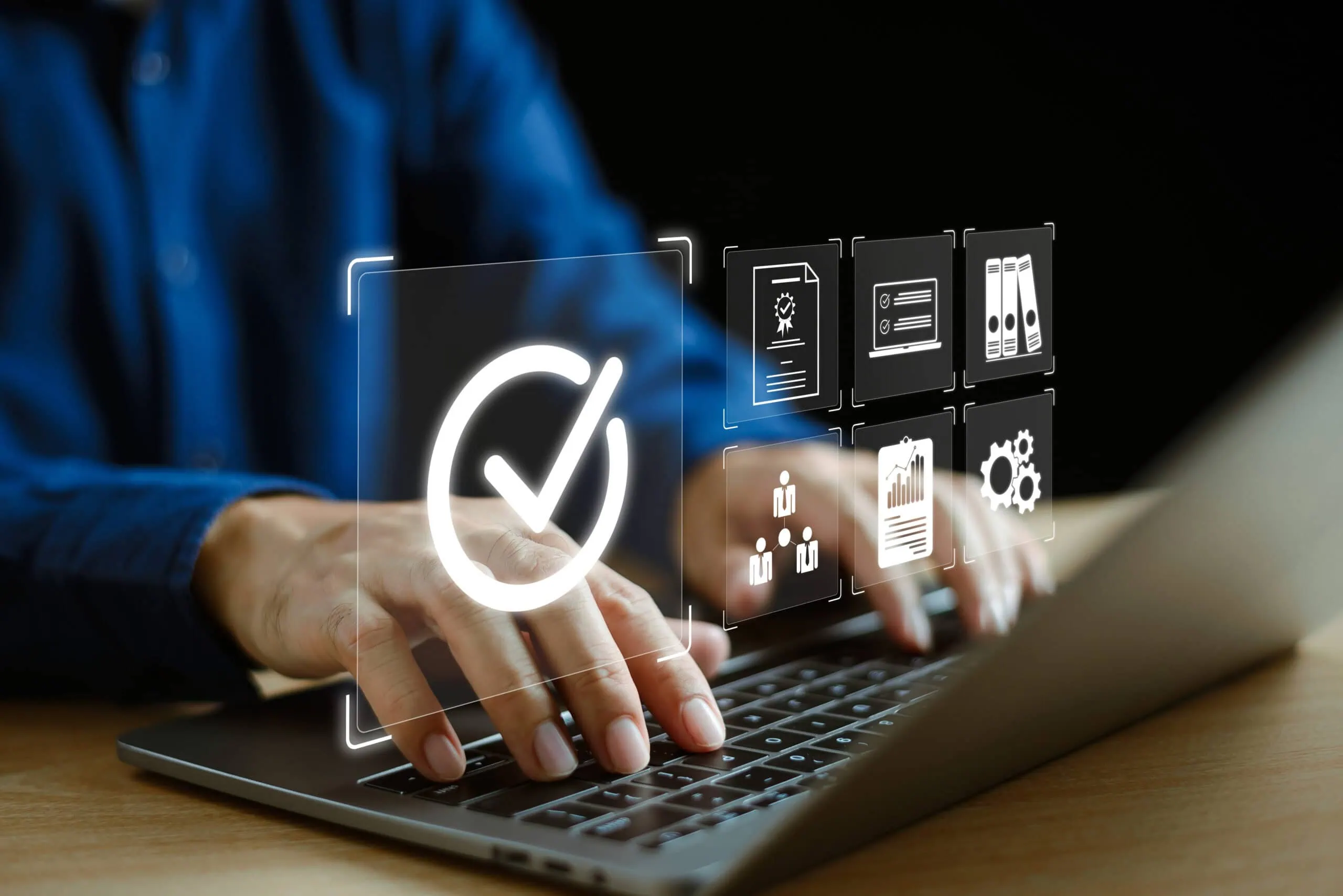 Person Using Futuristic Digital Interface with Checkmark | i3solutions Person using futuristic digital interface with checkmark and icons on laptop.