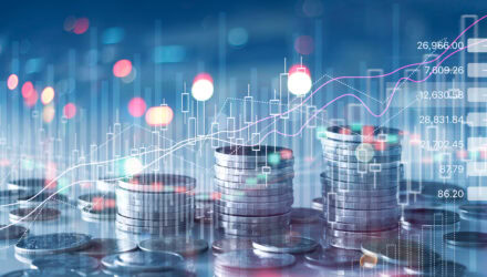 Financial growth with stacked coins and digital stock market graphs.