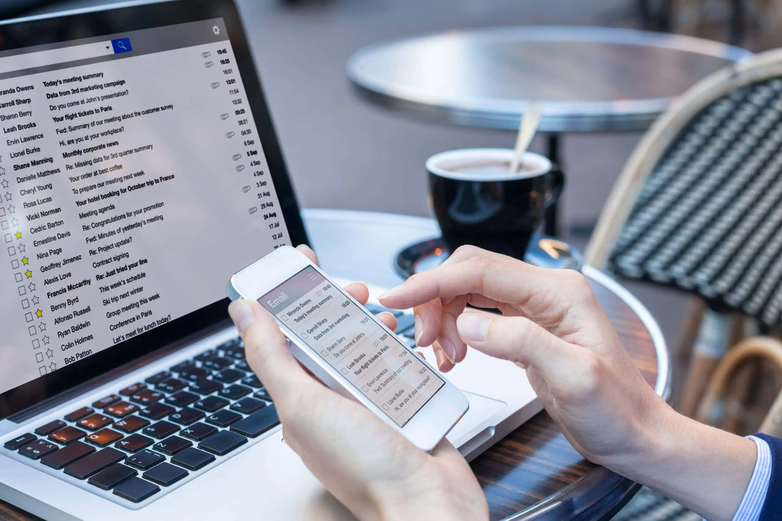 Person Using Smartphone and Laptop for Digital | i3solutions Person using smartphone and laptop for digital communication at a cafe.