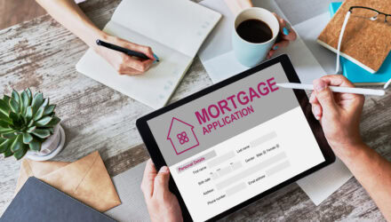 Person filling out a mortgage application on a tablet at a desk.