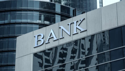 Modern bank building with reflective glass windows and a prominent 'BANK' sign.