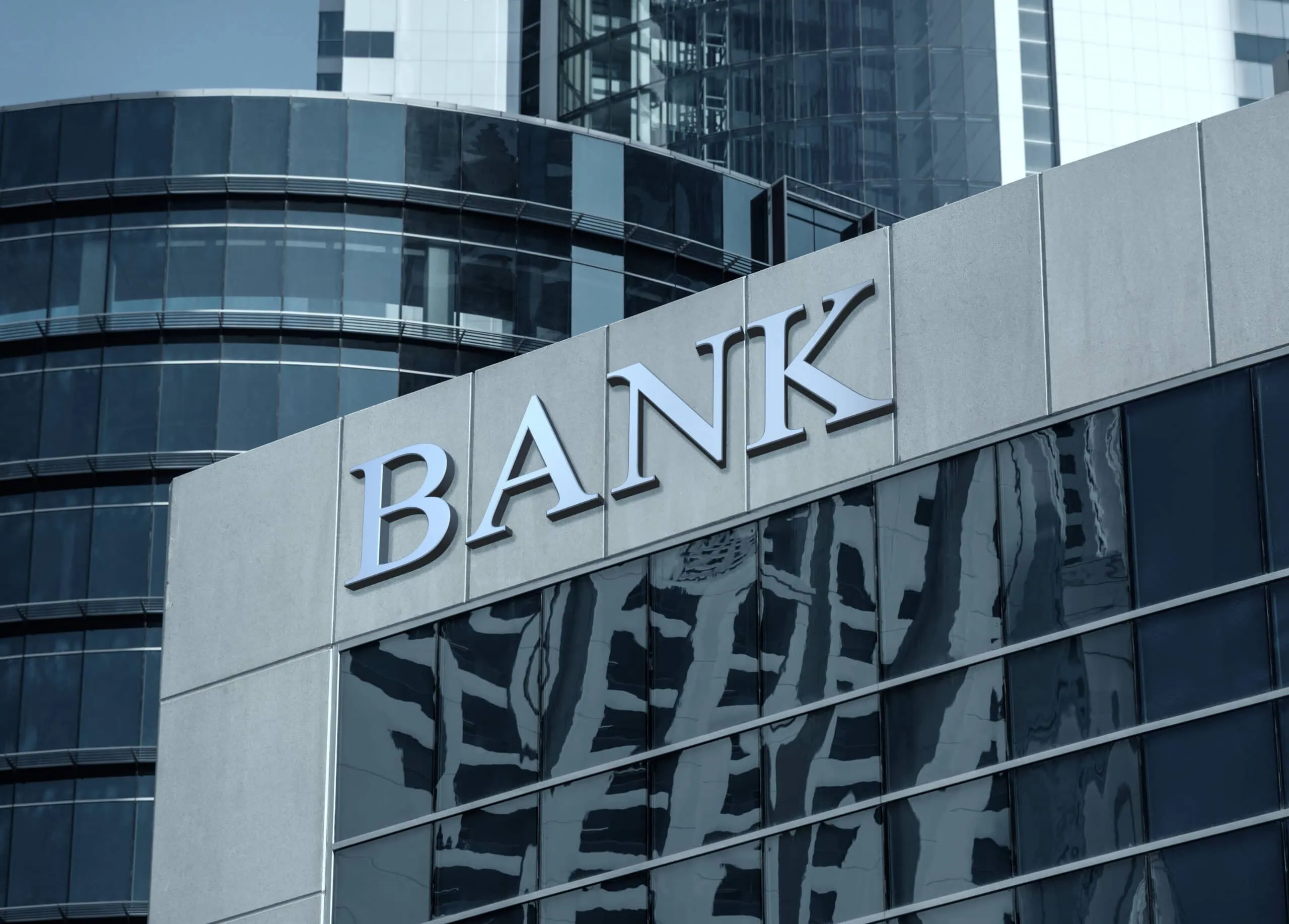 Modern Bank Building with Reflective Glass Windows | i3solutions Modern bank building with reflective glass windows and a prominent 'BANK' sign.