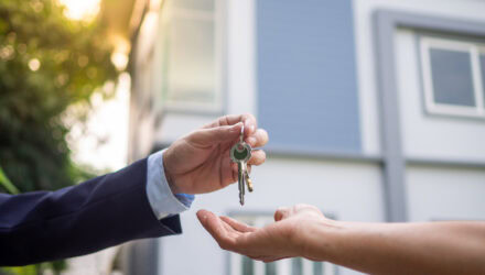 Person Handing Over Keys in Front | i3solutions Person handing over keys in front of a house during daytime.