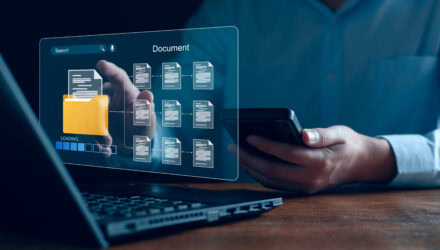 Business Person Using Smartphone with Digital Document | i3solutions Business person using smartphone with digital document interface and laptop.