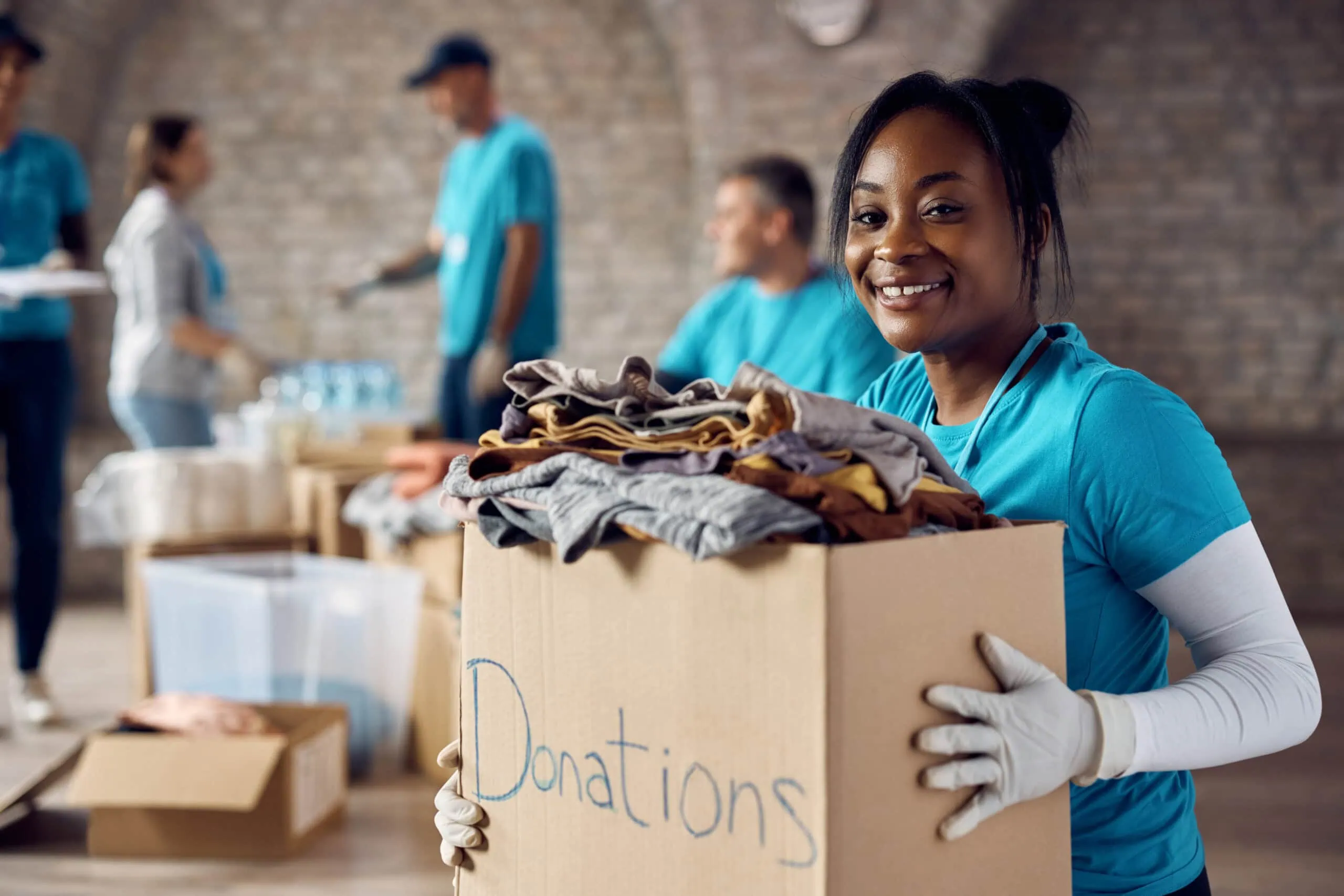 Smiling Woman Holding a Donations Box | i3solutions Smiling woman holding a donations box at a charity event.