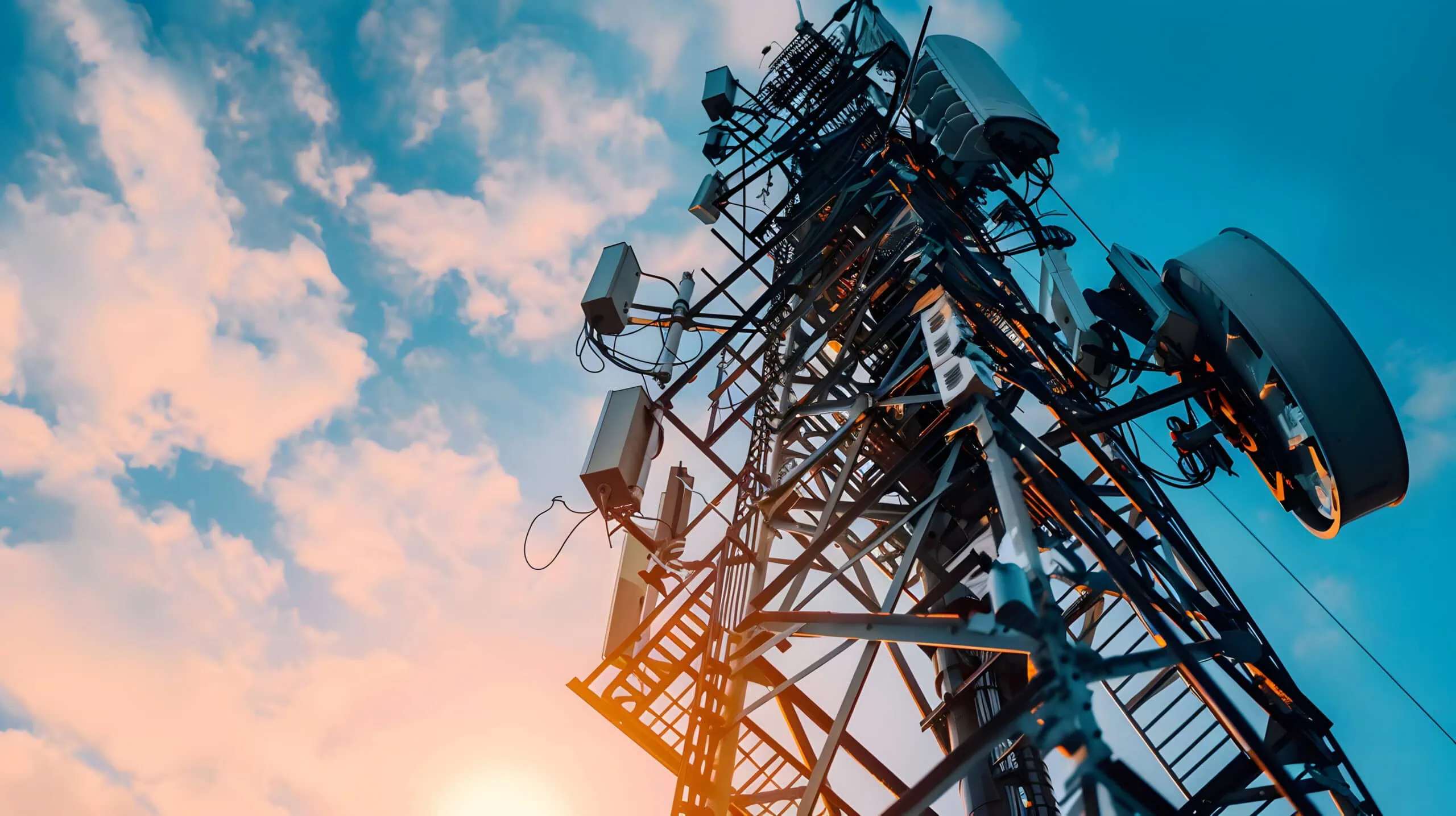 Telecommunications Tower with Antennas and Dishes Against | i3solutions Telecommunications tower with antennas and dishes against a sunset sky.