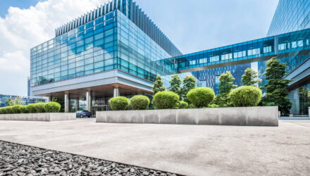 Modern Glass Office Building with Landscaped Surroundings | i3solutions Modern glass office building with landscaped surroundings and blue sky.