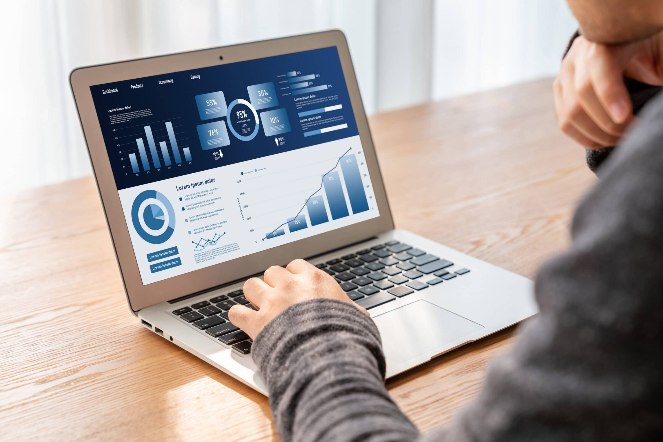 Business Person Analyzing Data on a Laptop | i3solutions Business person analyzing data on a laptop with charts and graphs.