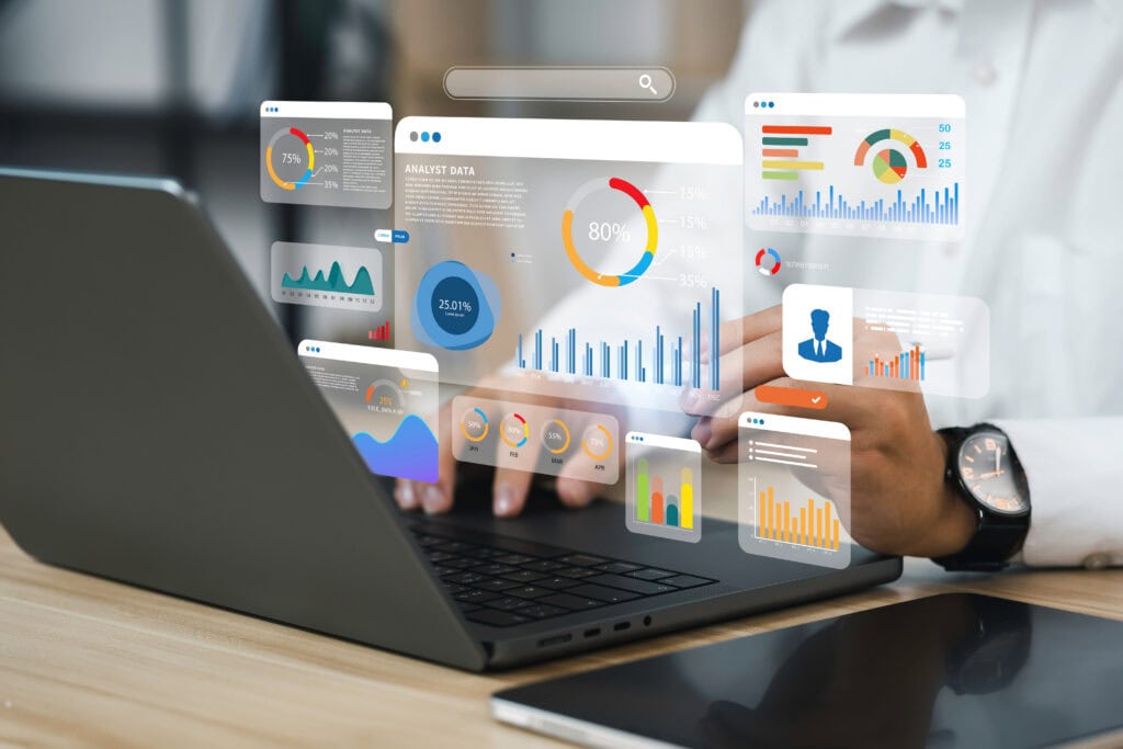 Business analyst working with digital data dashboards on a laptop.